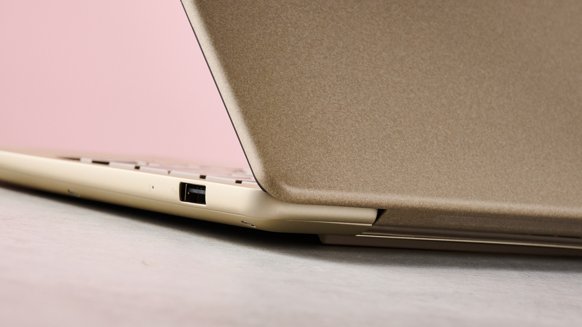 لقطة مقربة للزاوية الخلفية لجهاز Asus Zenbook 14 2026 مع جدار وردي في الخلفية