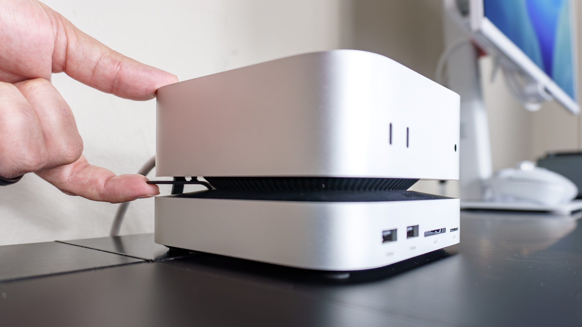 شخص يستخدم قاعدة Ugreen Mac mini M4 مع حامل للوصول بسهولة أكبر إلى زر الطاقة في Mac mini M4