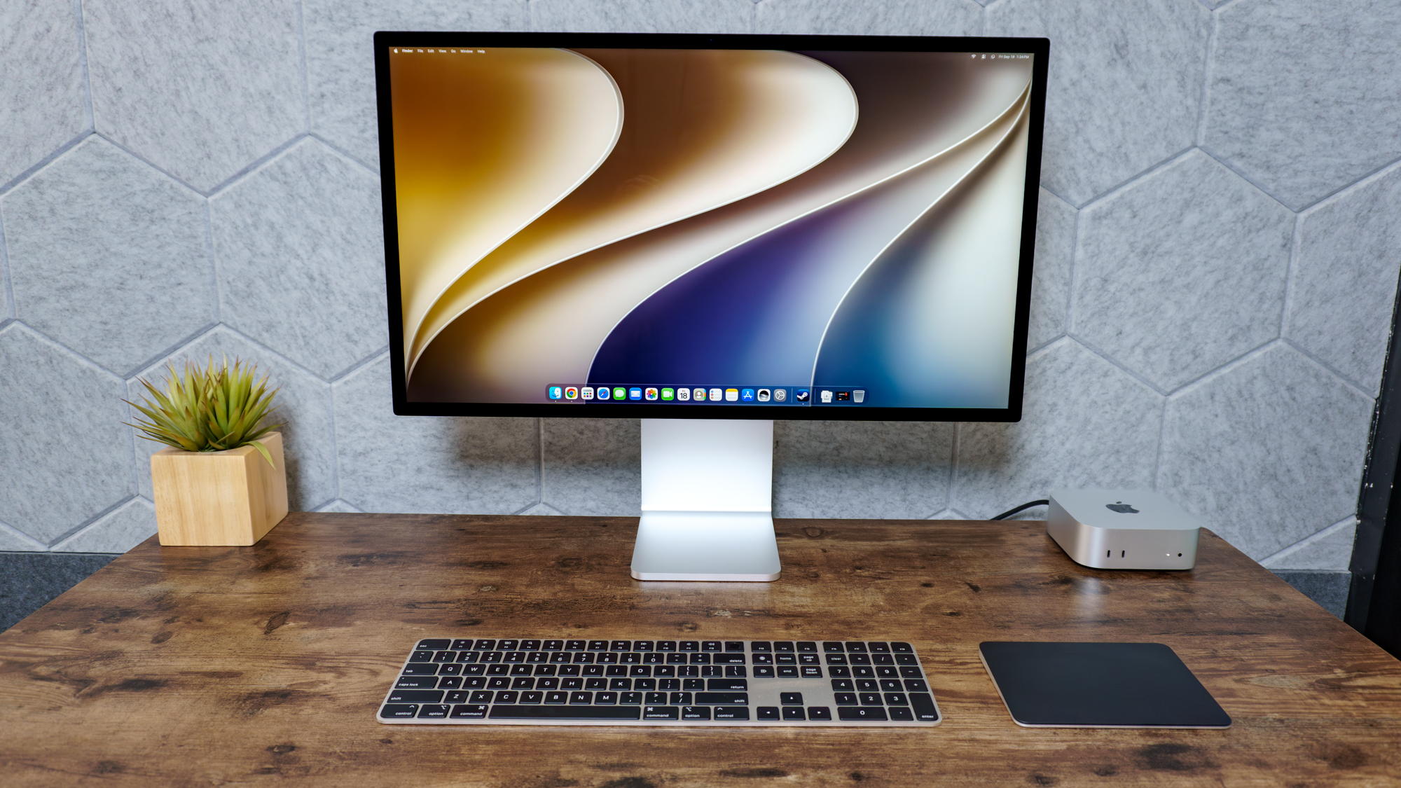 إعداد مكتب يضم جهاز Mac mini المزود بشريحة M6 مع شاشة Apple Studio Display XDR.