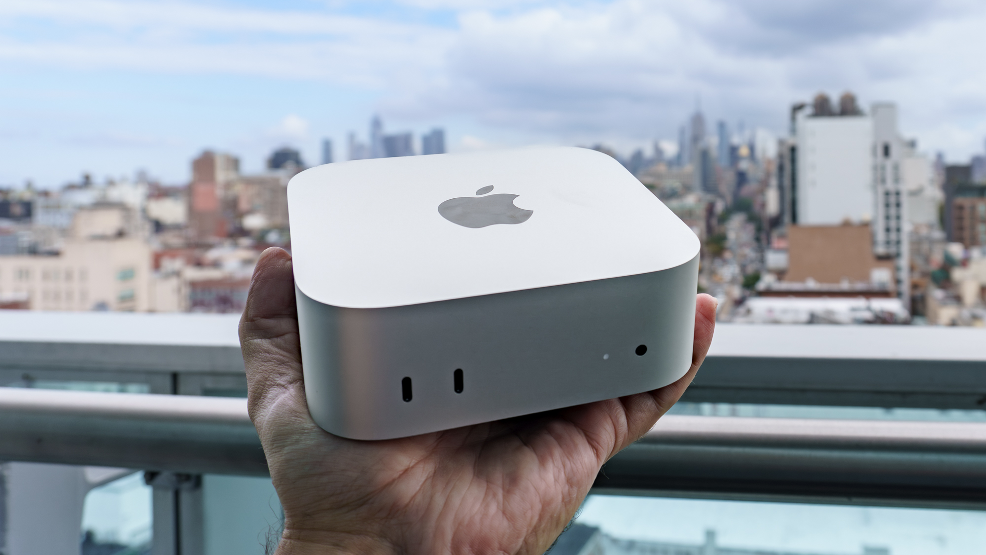 شخص يحمل جهاز Mac mini M6 في يده