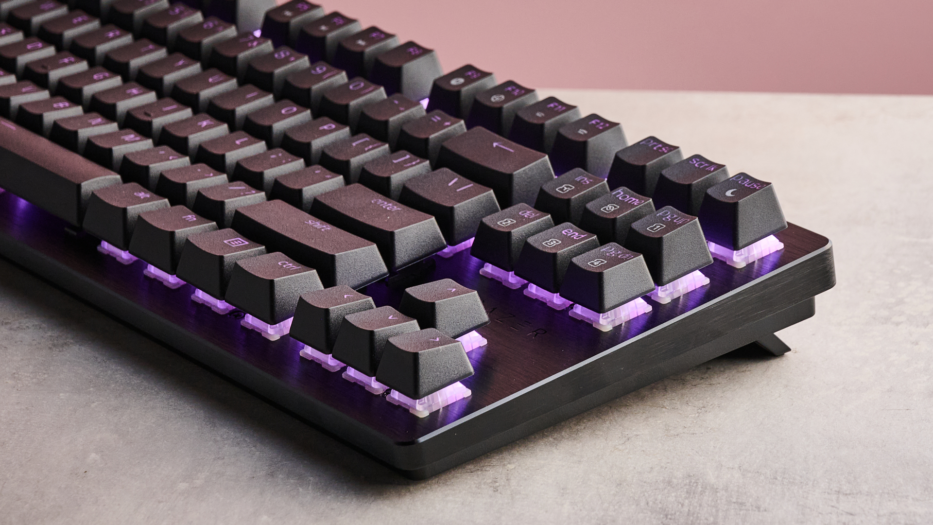 منظر ثلاثي الأرباع للجزء الأيمن من لوحة مفاتيح Razer Huntsman V3 HE Magnetic Tenkeyless 8KHz، على مكتب بخلفية جدار وردي