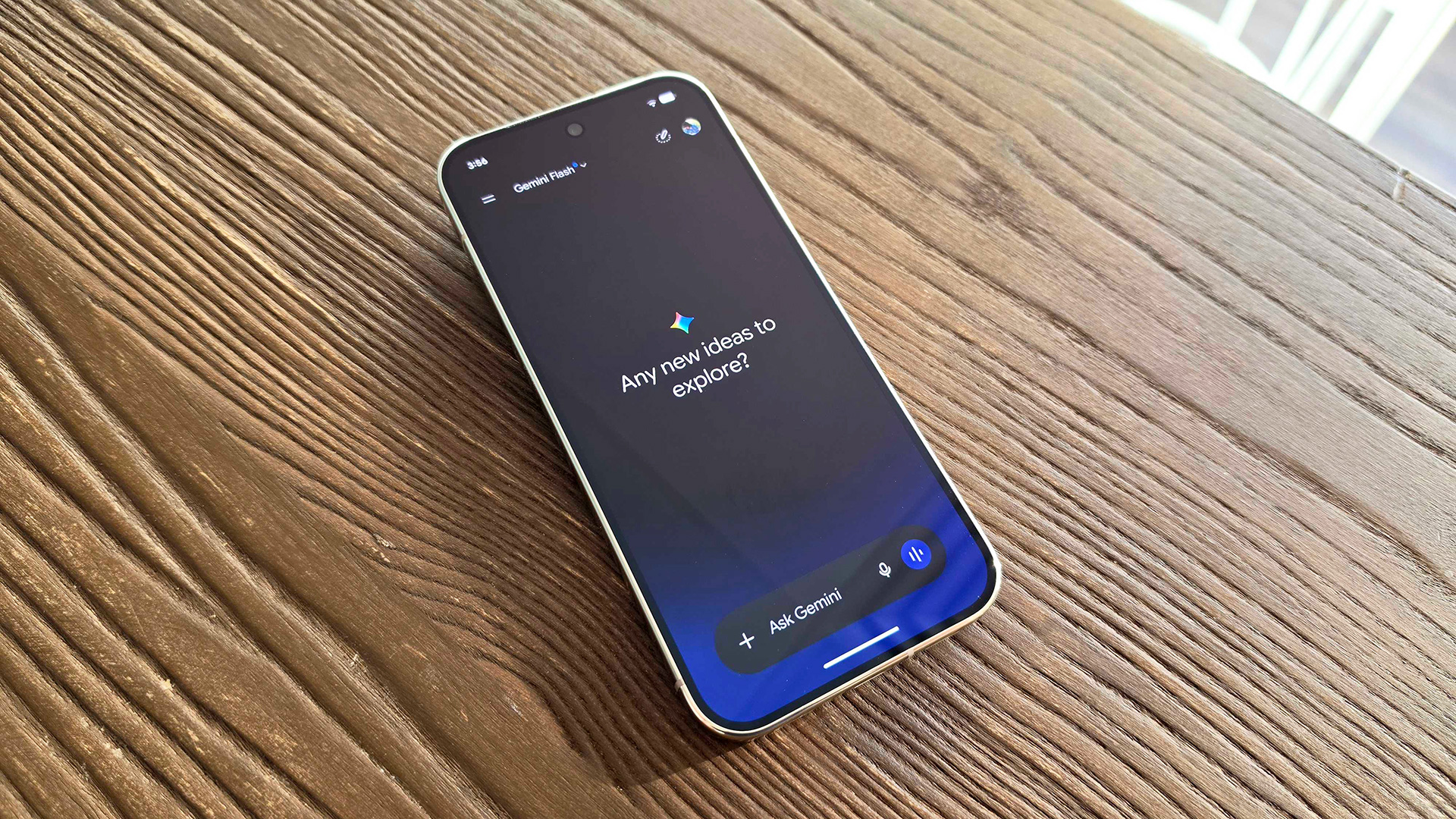 هاتف Google Pixel 11 Pro موضوعًا على طاولة مع تطبيق Gemini يسأل: "هل لديك أي أفكار جديدة لاستكشافها؟"