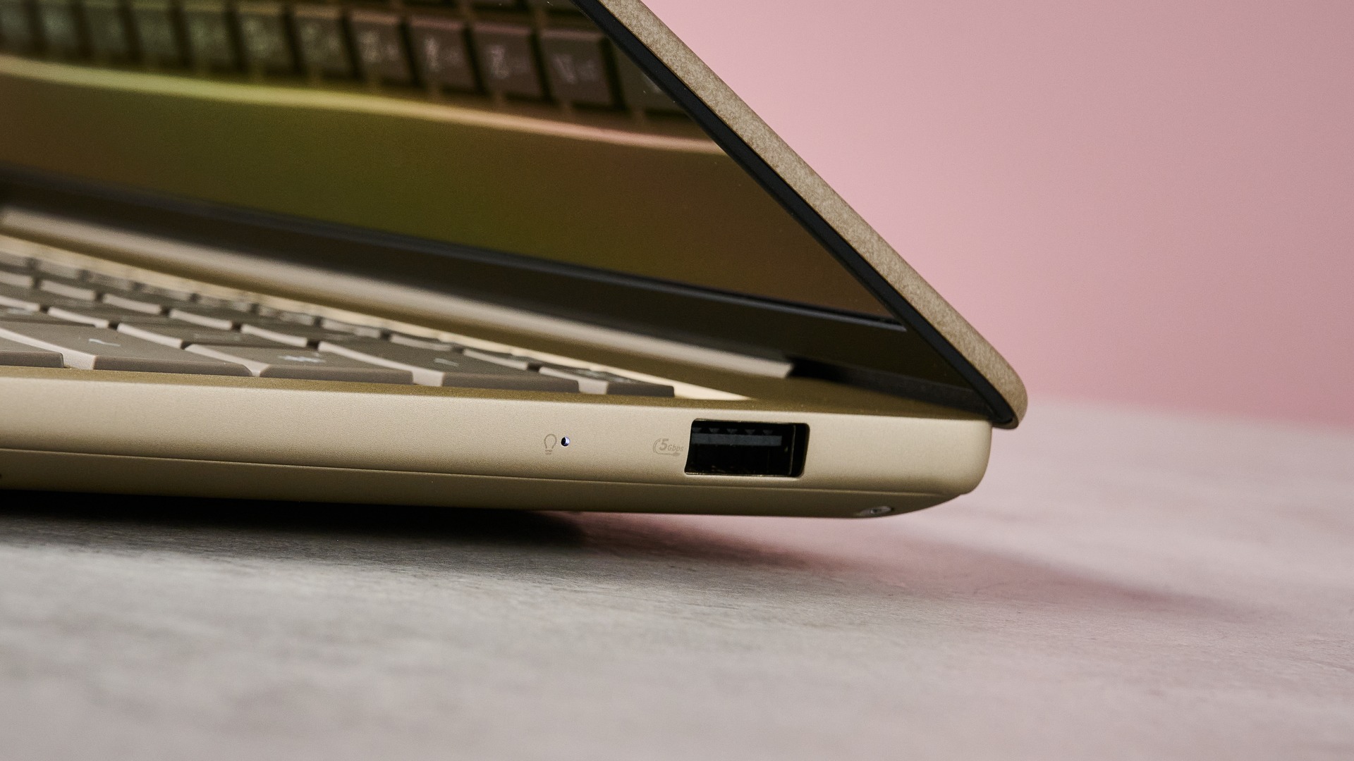 لقطة مقربة لمنفذ USB-A على الجانب الأيمن من Asus Zenbook 14 2026 مع جدار وردي في الخلفية