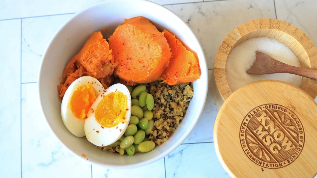 A protein bowl with sweet potato, an egg, and edamame next to an MSG cellar. 