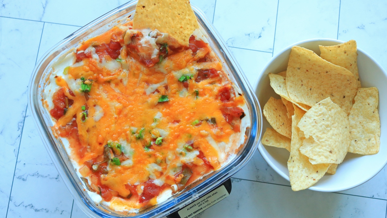 طبق من طبقات الدجاج مع صلصة Ninja Crispi بجانب رقائق التورتيلا.