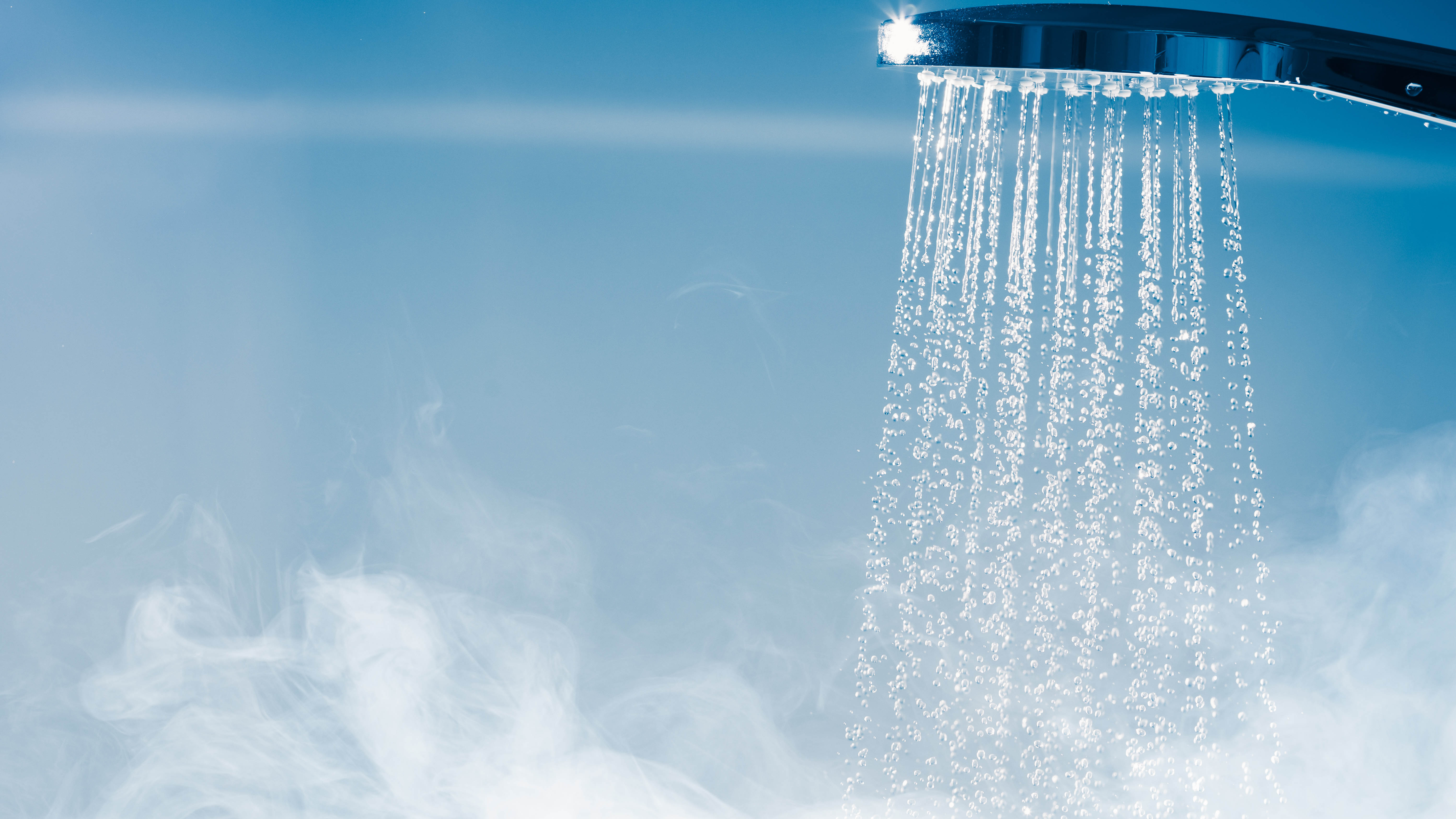 A running hot shower with steam forming below.