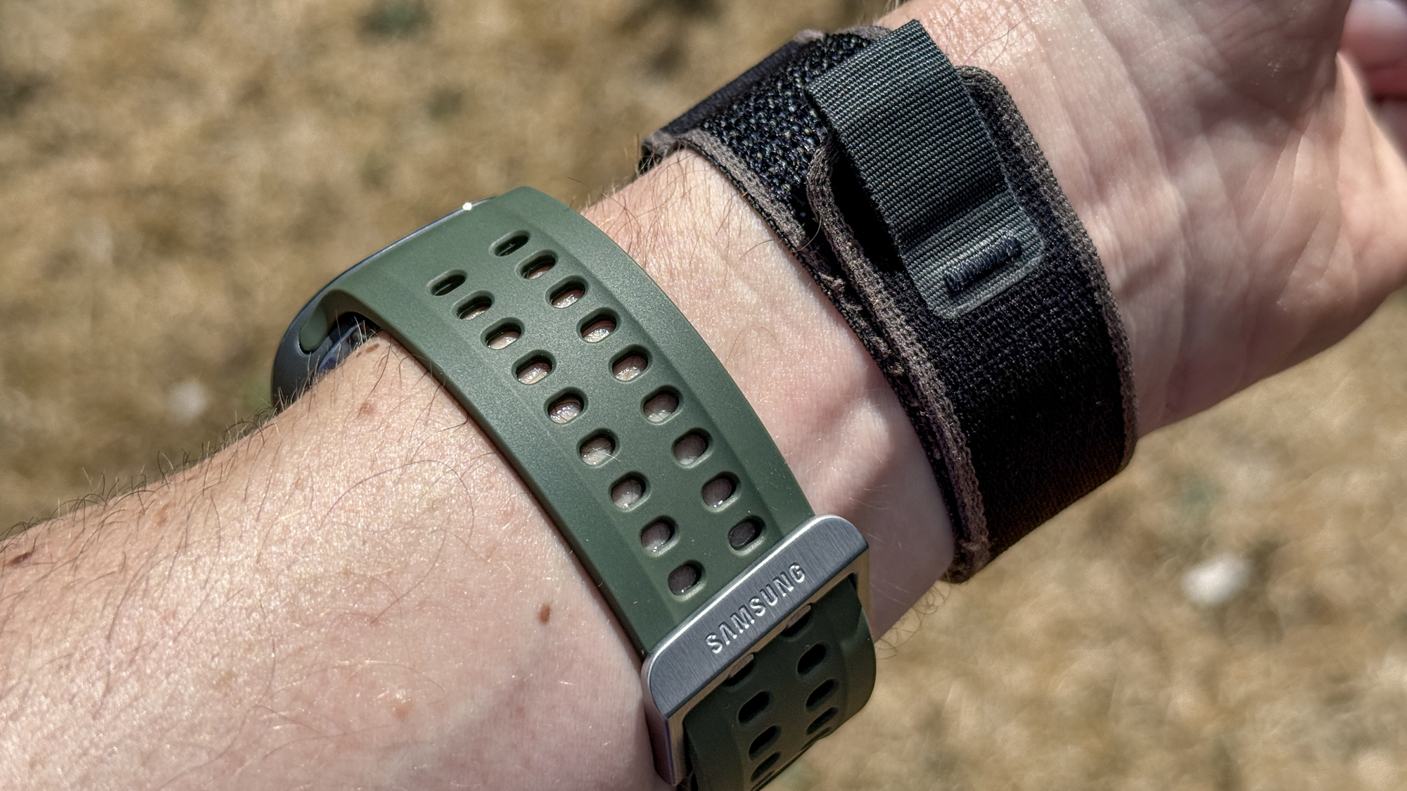 Samsung Galaxy Watch Ultra 2 e Apple Watch Ultra 2 al polso durante un'attività all'aperto.