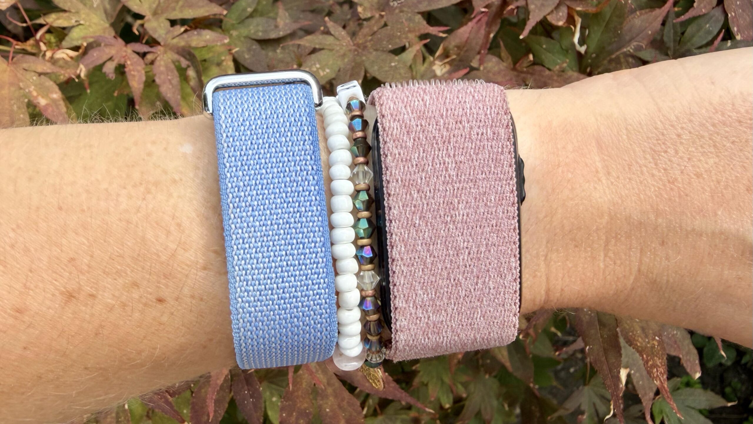 صورة لجهازي Fitbit Air 和 Garmin Cirqa على المعصم