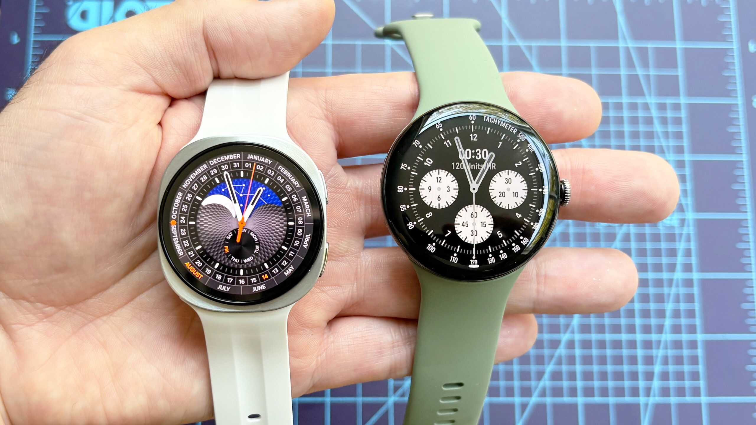 Uma foto em close do Samsung Galaxy Watch 9 ao lado do Google Pixel Watch 5.