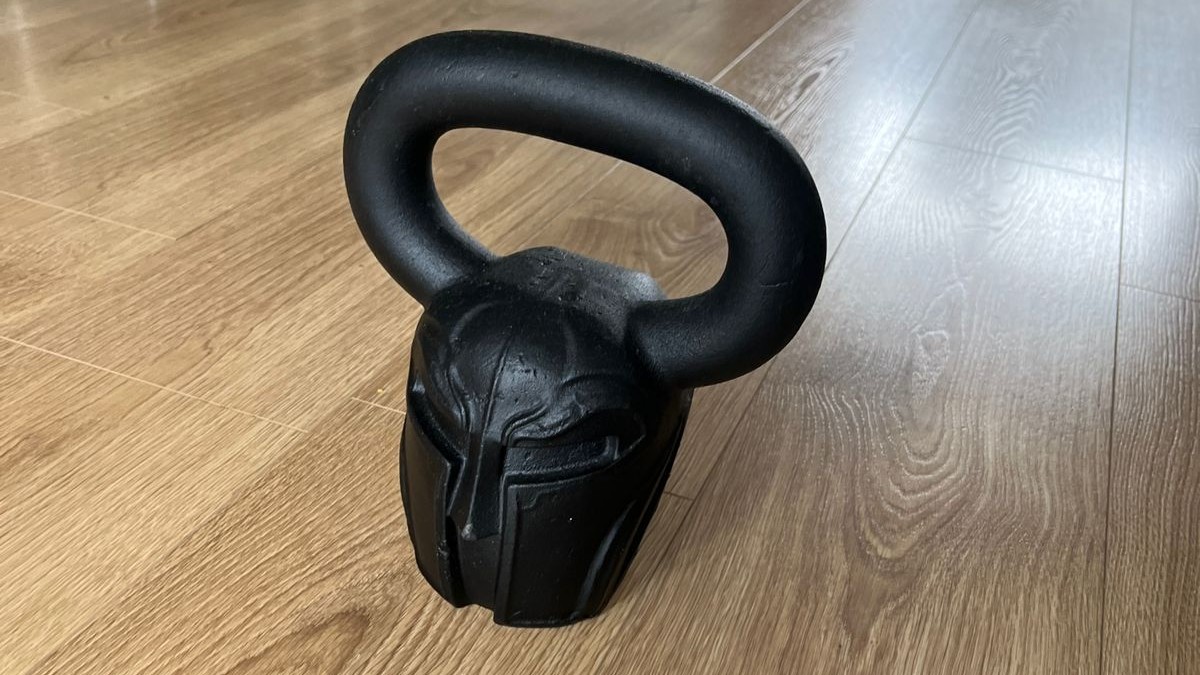 كيتل بيل سبارتان بيل من Gravity Fitness على أرضية خشبية أثناء اختبار أفضل كيتل بيل