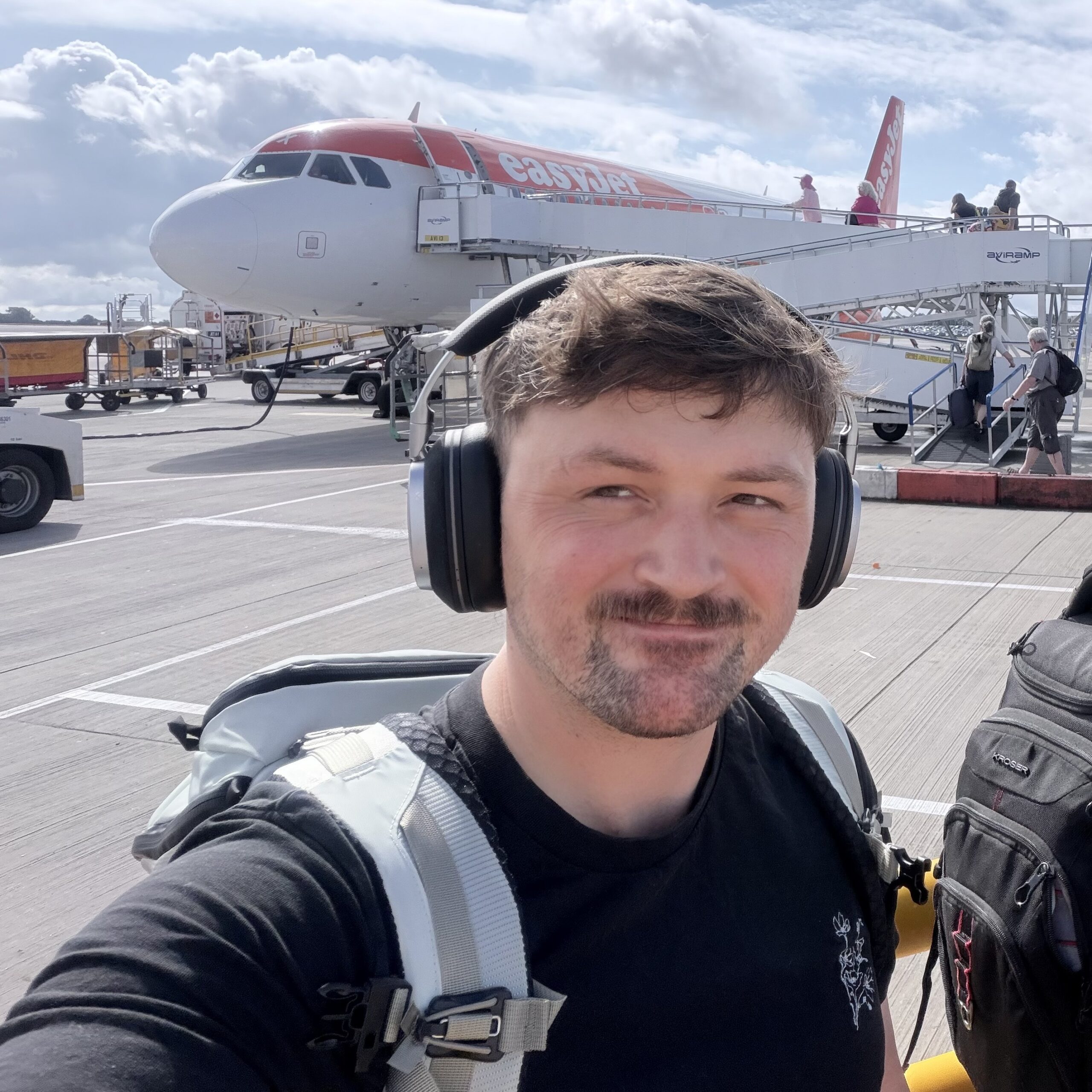 المحرر الأول بيت وولينسكي يرتدي سماعات Noble FoKus Artemis وحقيبة ظهر Yeti Skala، على وشك الصعود إلى رحلة EasyJet