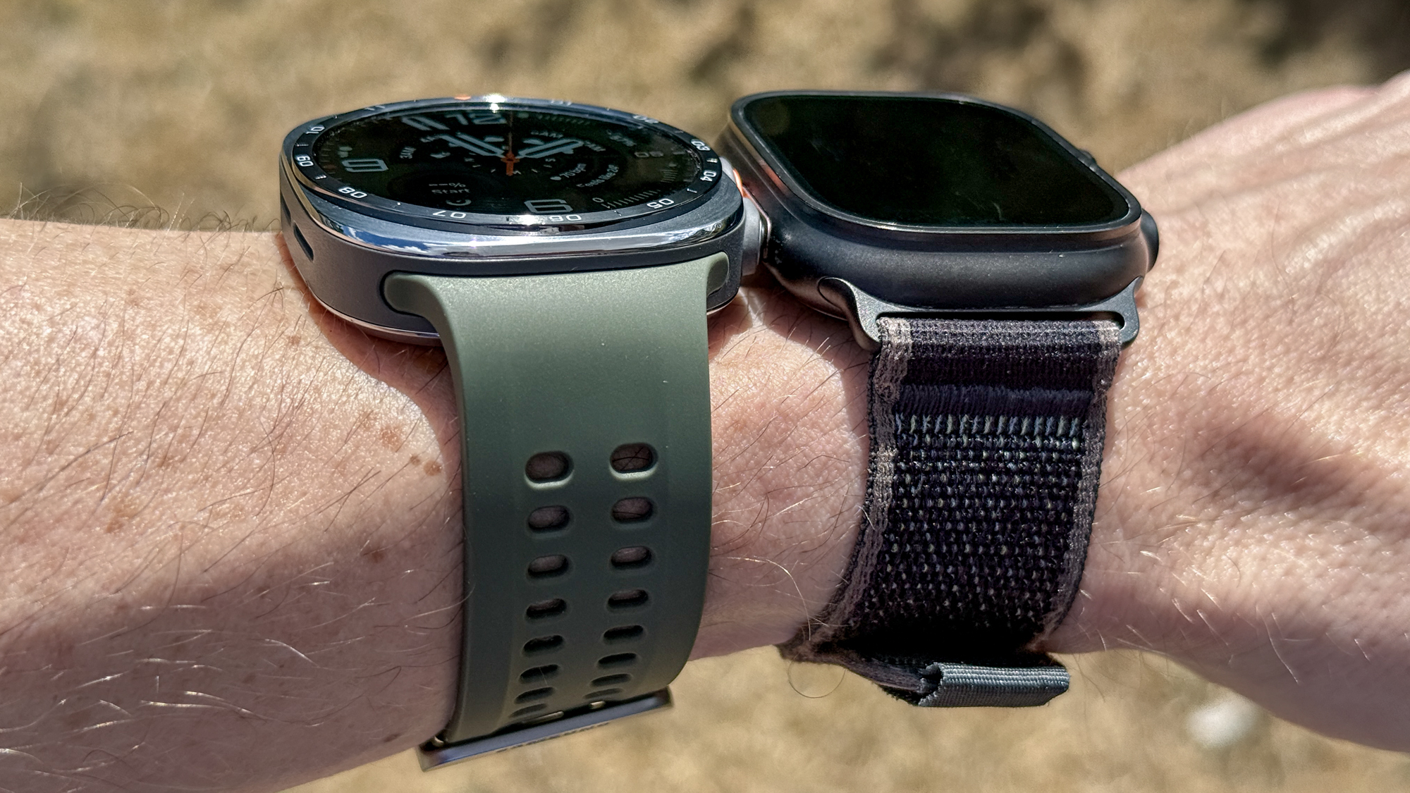Samsung Galaxy Watch Ultra 2 e Apple Watch Ultra 2 al polso durante un'attività all'aperto.
