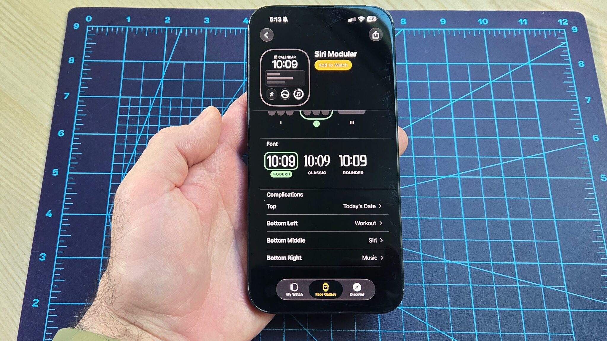 لقطة مقربة لهاتف iPhone 16 Plus توضح كيفية إضافة ويدجت عداد الخطوات الجديد إلى واجهة ساعة Apple Watch الخاصة بك