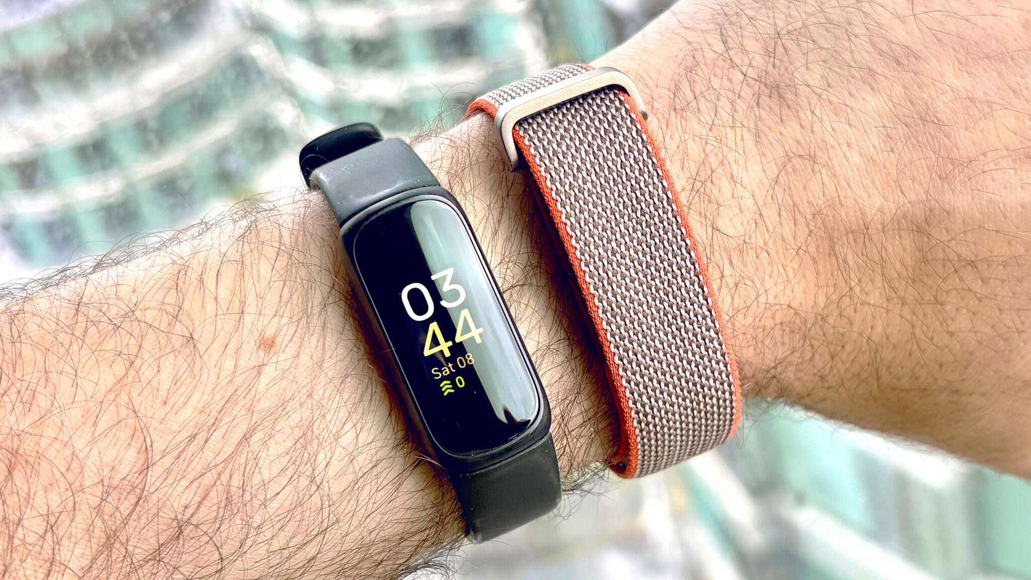 لقطة مقربة لجهاز Fitbit Inspire 3 بجانب Fitbit Air على معصم المستخدم