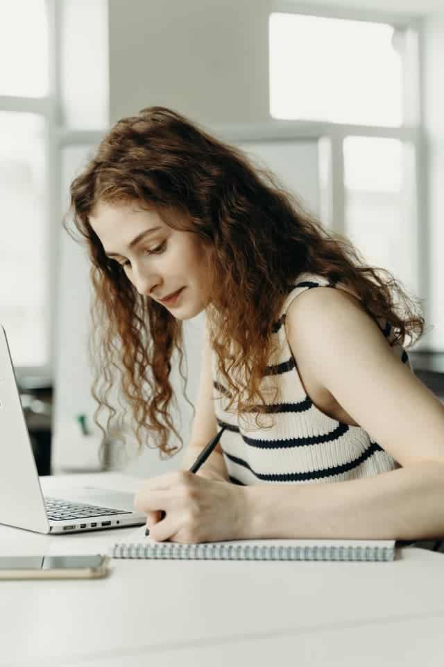 امرأة تكتب في دفتر ملاحظات